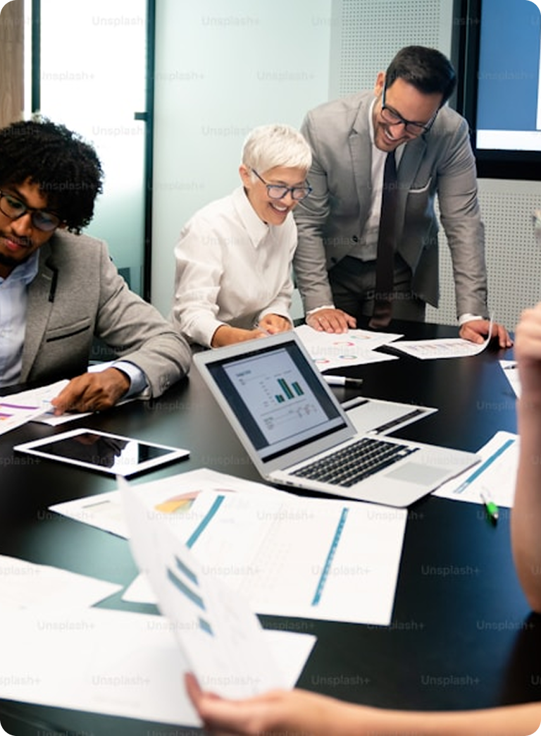 Experienced accountants collaborating with clients over documents and a laptop